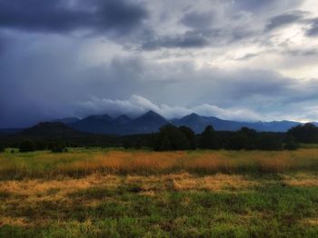 Scenic view of landscape against storm clouds
