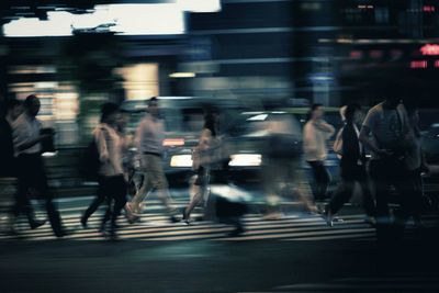 Blurred motion of people walking on street at night