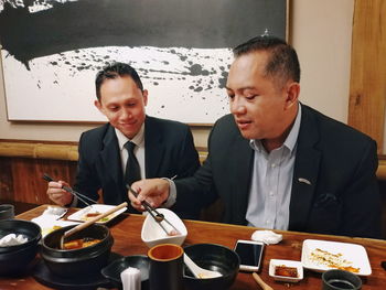 Father and daughter sitting on table