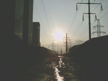 Close-up of wet road against sky during sunset