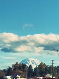 Trees and mountains against blue sky