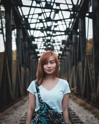 Young woman standing on bridge
