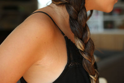 Midsection of teenage girl with braided hair at home