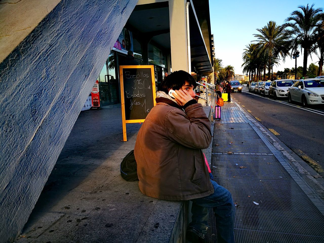 MIDSECTION OF MAN WITH UMBRELLA IN CITY