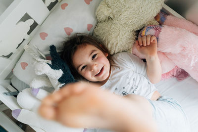 High angle view of baby girl lying on bed at home