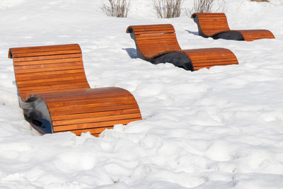 High angle view of empty bench on snow covered field during winter