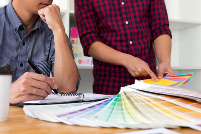 Midsection of business people working on table