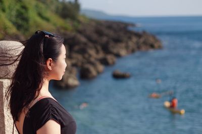 Side view of woman looking at sea