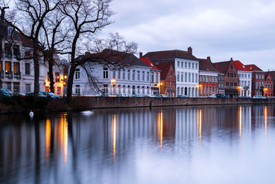 Reflection of buildings on river against sky