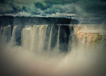 Scenic view of waterfall against sky