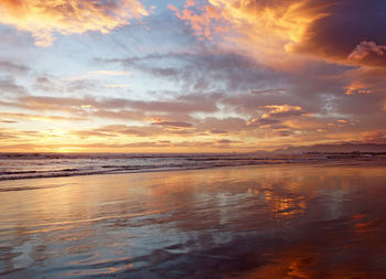 Scenic view of beach against sky during sunset