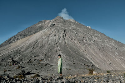 Full length of boy standing against volcano