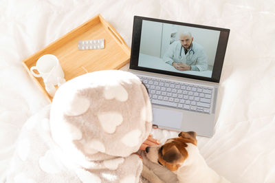 High angle view of woman using laptop on bed