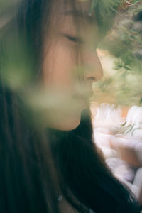 Close-up portrait of woman looking at window