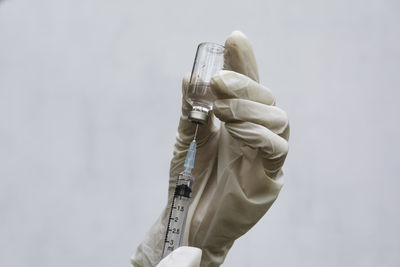 Close-up of person holding hands against white background