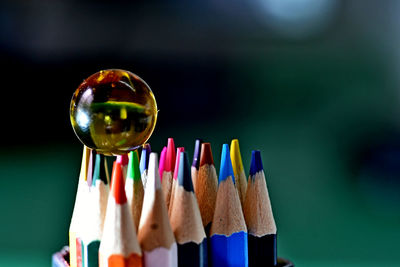 Marbles supported on drawing pencils