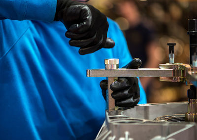 Close-up of person working with blue metal