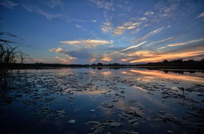 Scenic view of lake against sky at sunset