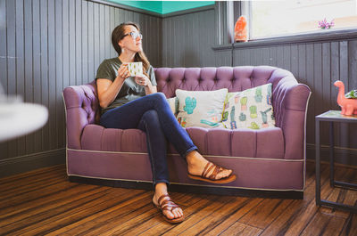 Young woman sitting on sofa