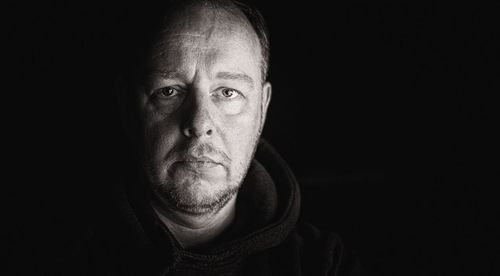 Portrait of man against black background