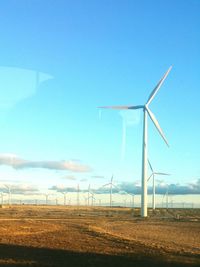 Windmill on wind turbines against sky