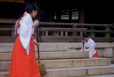 Full length of woman standing on steps