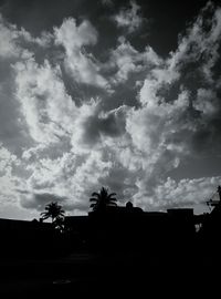 Silhouette of trees against cloudy sky