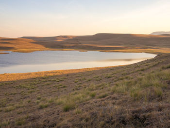 Scenic view of field against sky at sunset