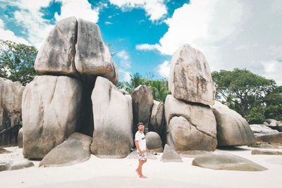 Full length of man standing on rock against sky