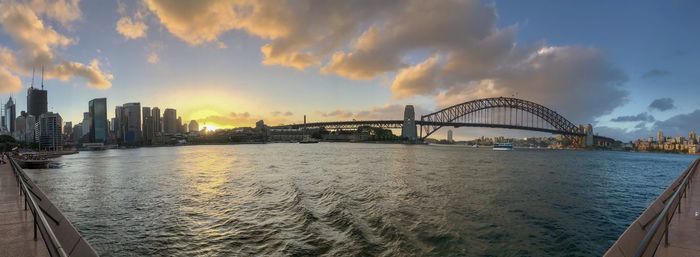 Panoramic view of bridge over river and buildings against sky