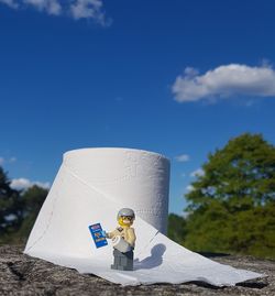 Man holding umbrella against blue sky