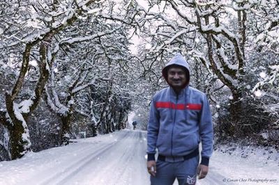 Young man standing on snow covered road