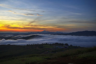 Scenic view of dramatic sky over land during sunset