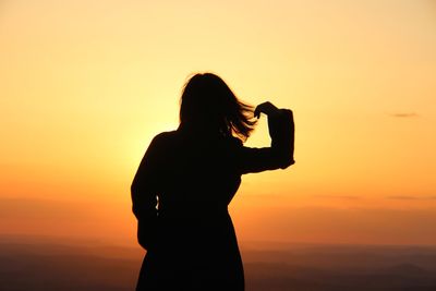 Silhouette woman standing against orange sky6