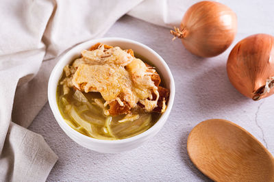 French onion soup with baked cheese bread in a bowl on the table