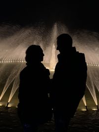 Silhouette friends standing against sea