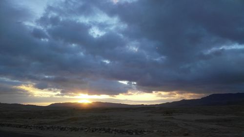 Scenic view of desert against sky during sunset