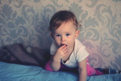 Baby girl on bed at home