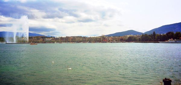 Buildings in city against cloudy sky