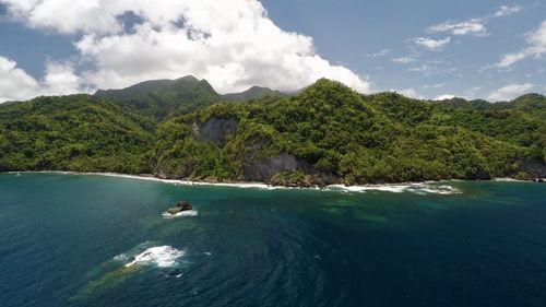 Scenic view of sea and mountains against sky