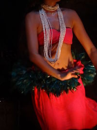 Close-up of young woman with red hair standing at night