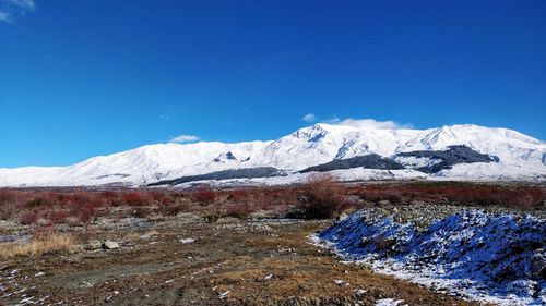 Scenic view of snowcapped mountains against clear blue sky