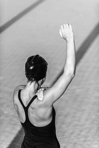 Woman in swimwear warming up against swimming pool
