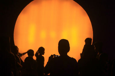 Rear view of silhouette people against sky during sunset