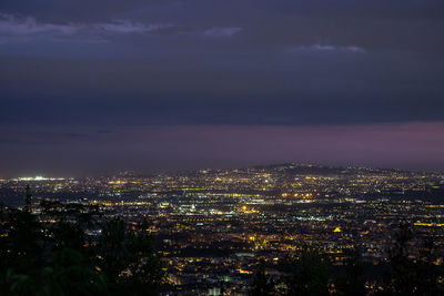 Illuminated cityscape against sky at night
