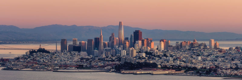 Panoramic view of city by sea against sky