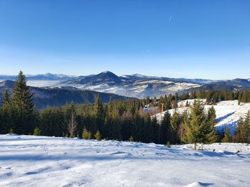 Scenic view of snowcapped mountains against clear blue sky