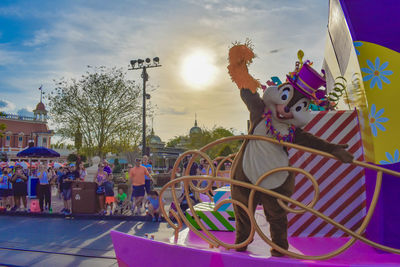 People at amusement park against sky