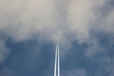 Low angle view of airplane against cloudy sky