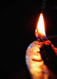 Close-up of lit candle in the dark